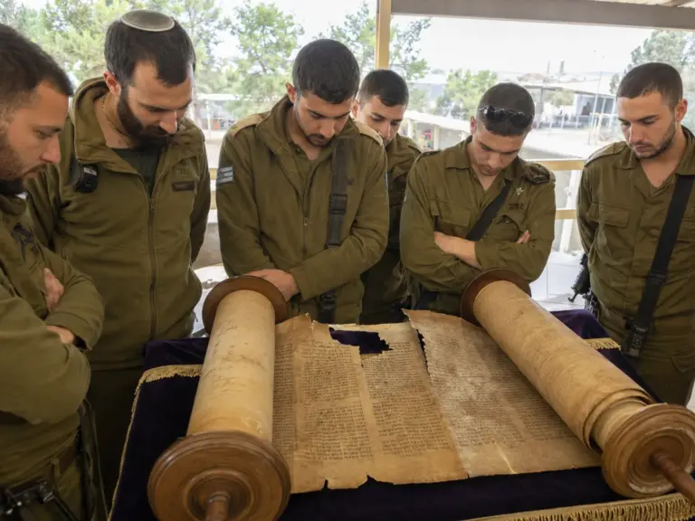 חיילים מתבוננים בספר תורה ישן שנפגע ונפסל בבסיס